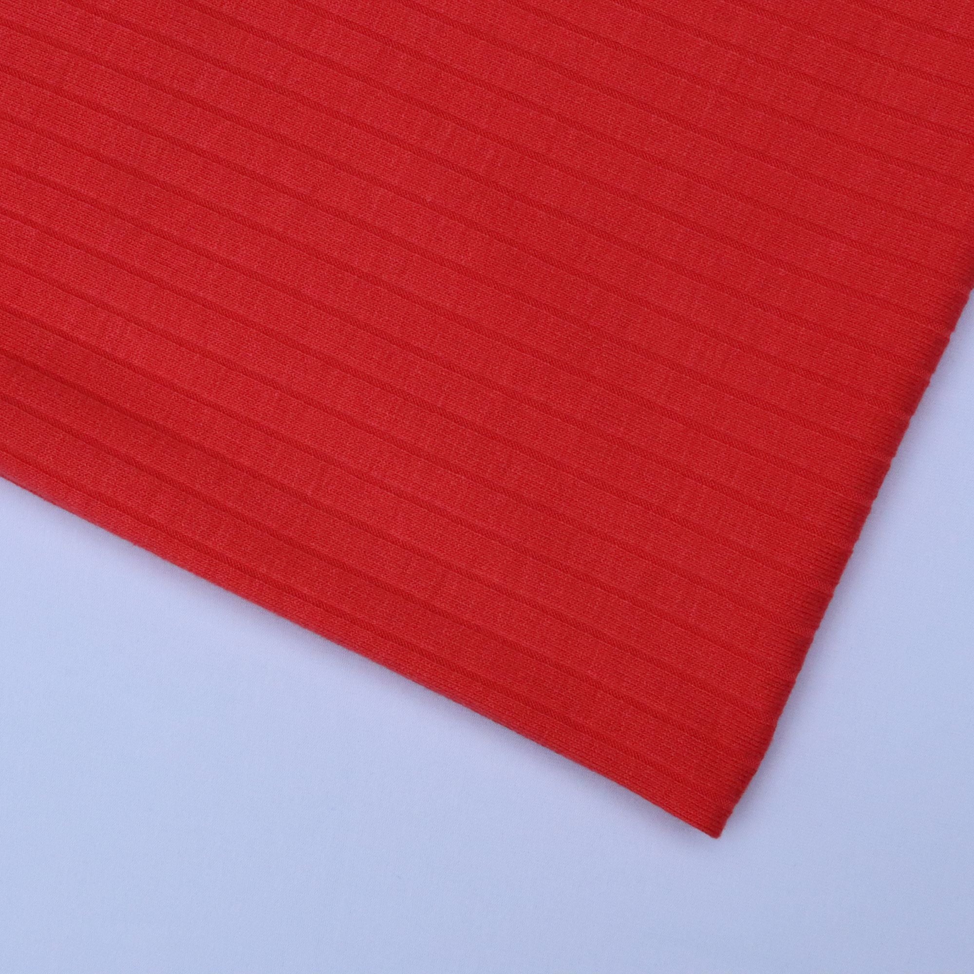 Red fabric with a ribbed texture on a white background