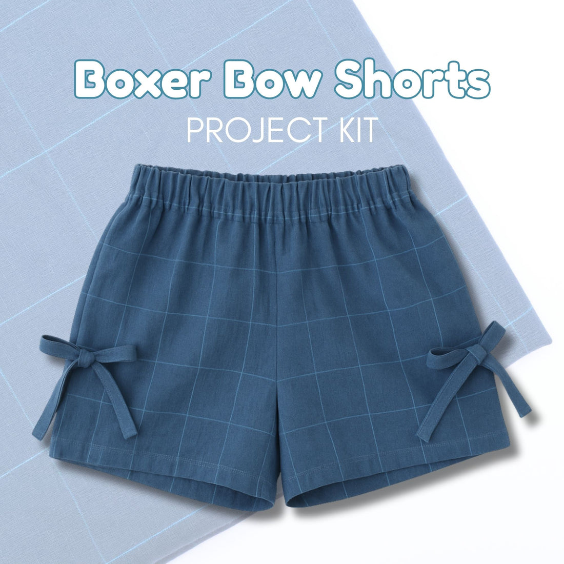 Blue boxer bow shorts on a light blue grid background with text &