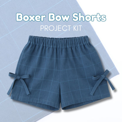 Blue boxer bow shorts on a light blue grid background with text &