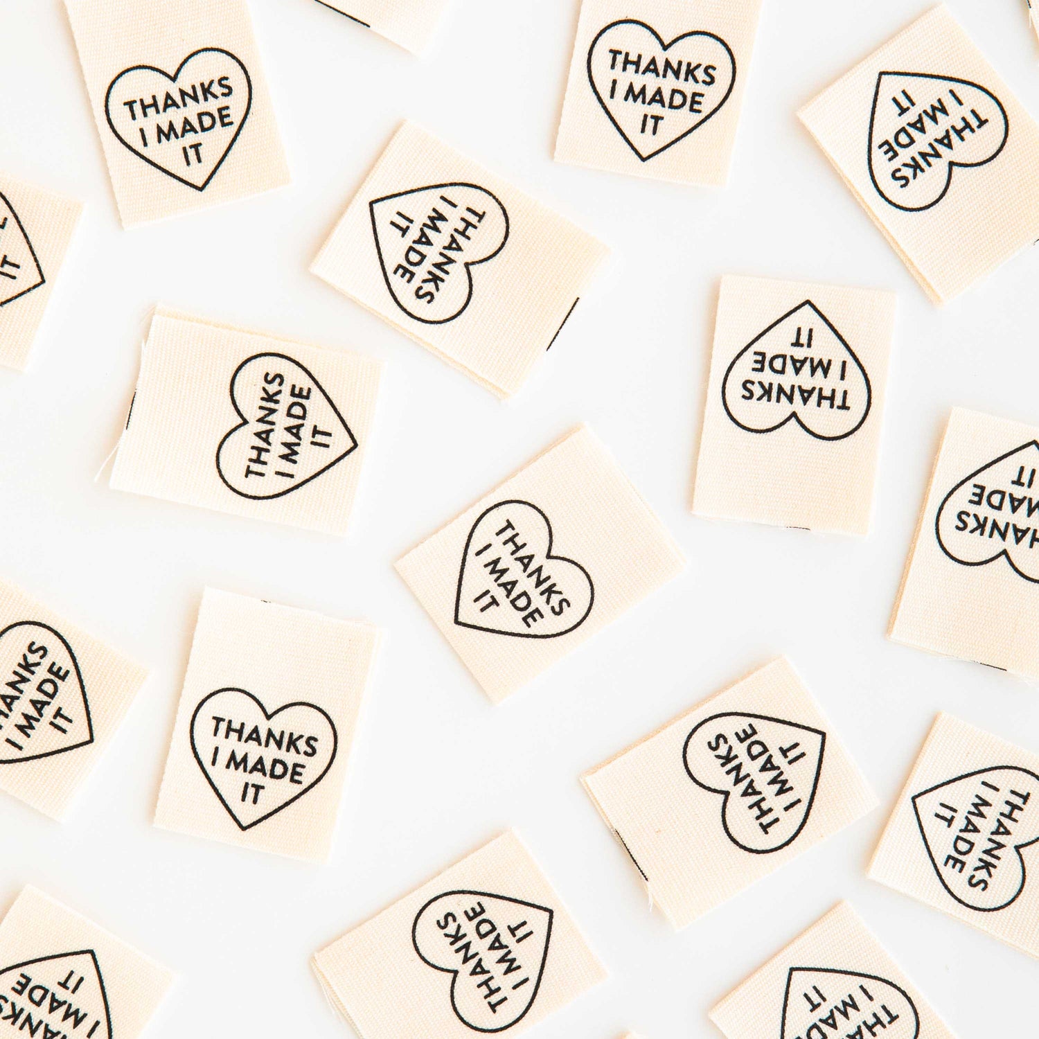 Woven Labels scattered around the image, with the heart shaped design and text saying &