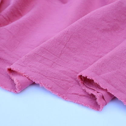Close-up of pink fabric with a soft texture on a light blue background