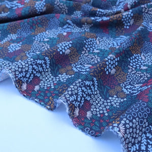 Patterned fabric with blue and multicolor design on a white background