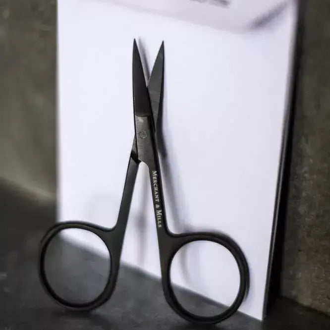 Wide Bow Black Scissors standing up against white packaging