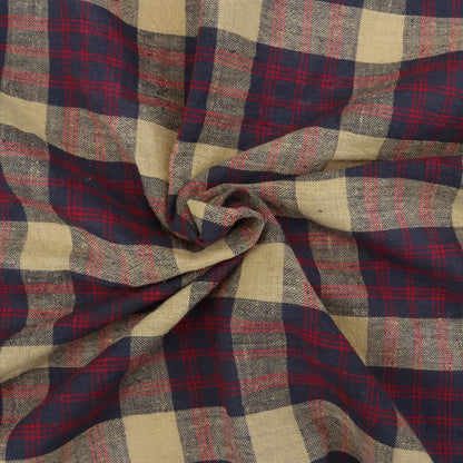 Close-up of plaid fabric with red, blue, and beige colors.