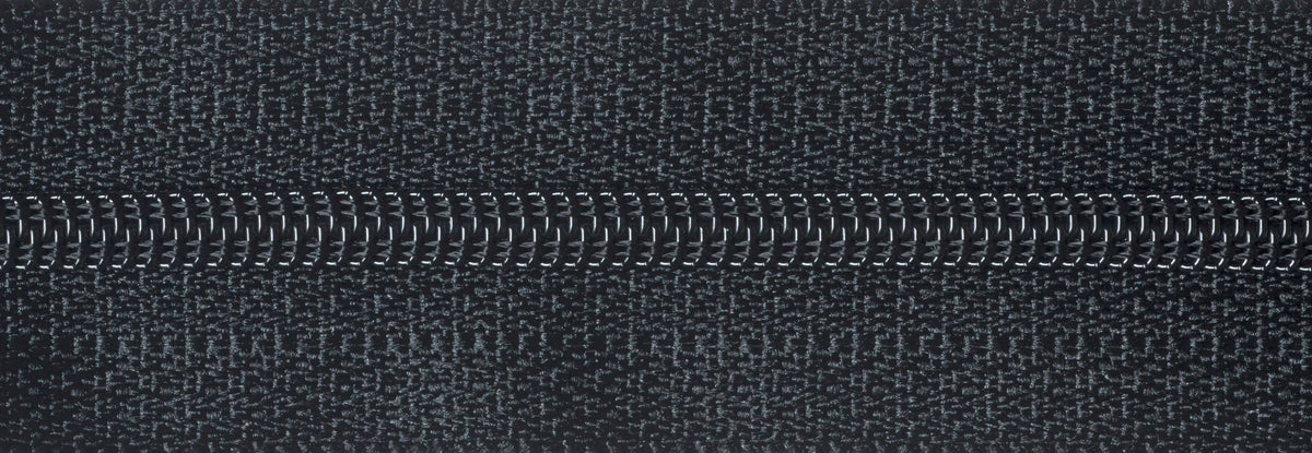 Close-up of a black zipper on a textured fabric background